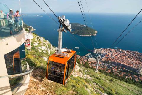 Travel: Orange cable car ascending the hills above the fortified city of Dubrovnik in Croatia.