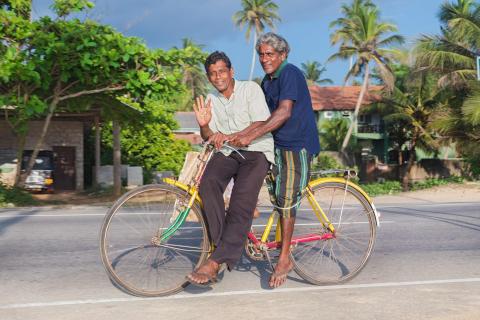 Travel: Two elderly men travelling on bicycle in the coastal town of Hikkaduwa, Sri Lanka.