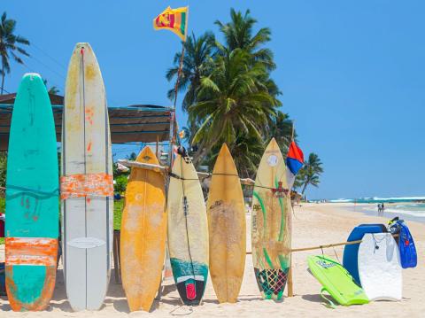 Travel: Surf boards standing at local surf school on sandy beach in Weligama, Sri Lanka.