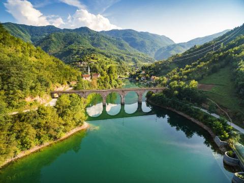 Bosnian landscape of lake, bridge and mountains.