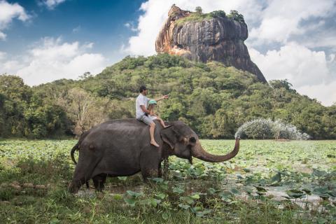 Father and daughter on elephant in Sigiriya, Sri Lanka.